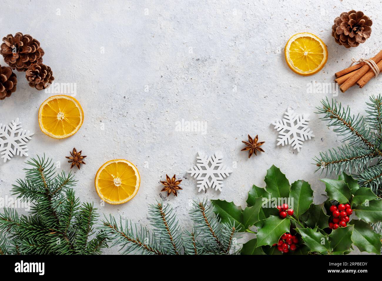 Decorazioni natalizie con bacche di holly e rami d'albero sul tavolo. Foto Stock