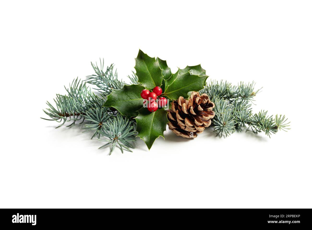 Decorazione natalizia di bacche di holly e cono di pino. Decorazione tradizionale festiva su sfondo bianco. Foto Stock