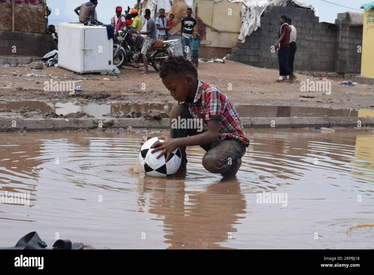 (190609) -- ADEN (YEMEN), 9 giugno 2019 -- Un bambino si lava la palla vicino al suo campo di sfollamento dopo forti piogge alla periferia di Aden, Yemen, il 9 giugno 2019. Le forti piogge e le inondazioni hanno colpito diverse parti delle province meridionali e orientali dello Yemen domenica, lasciando almeno tre morti e molti altri feriti, hanno detto fonti di sicurezza locali. Migliaia di yemeniti sfollati interni con sede nella periferia di Aden soffrivano maggiormente per le forti piogge che danneggiarono i loro luoghi di dimora improvvisati. ) YEMEN-ADEN-SFOLLATI-PIOGGE INTENSE MURADXABDO PUBLICATIONXNOTXINXCHN Foto Stock