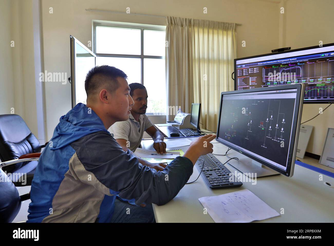 (190618) -- ADDIS ABEBA, 18 giugno 2019 (Xinhua) -- Guo Yongqiang, membro dello staff di China Electric Power Equipment and Technology Co., Ltd (CET), guida un dipendente locale presso il centro di controllo della rete di Adama, Etiopia, 11 giugno 2019. L'alimentazione elettrica costante è stata ottenuta da un progetto di distribuzione dell'energia elettrica di costruzione cinese, riabilitazione e potenziamento che coinvolge 8 città etiopiche è stato messo in funzione nel marzo 2019. (Xinhua/Wang Teng) ETIOPIA-ADAMA-CINA-POWER-PROJECT PUBLICATIONxNOTxINxCHN Foto Stock