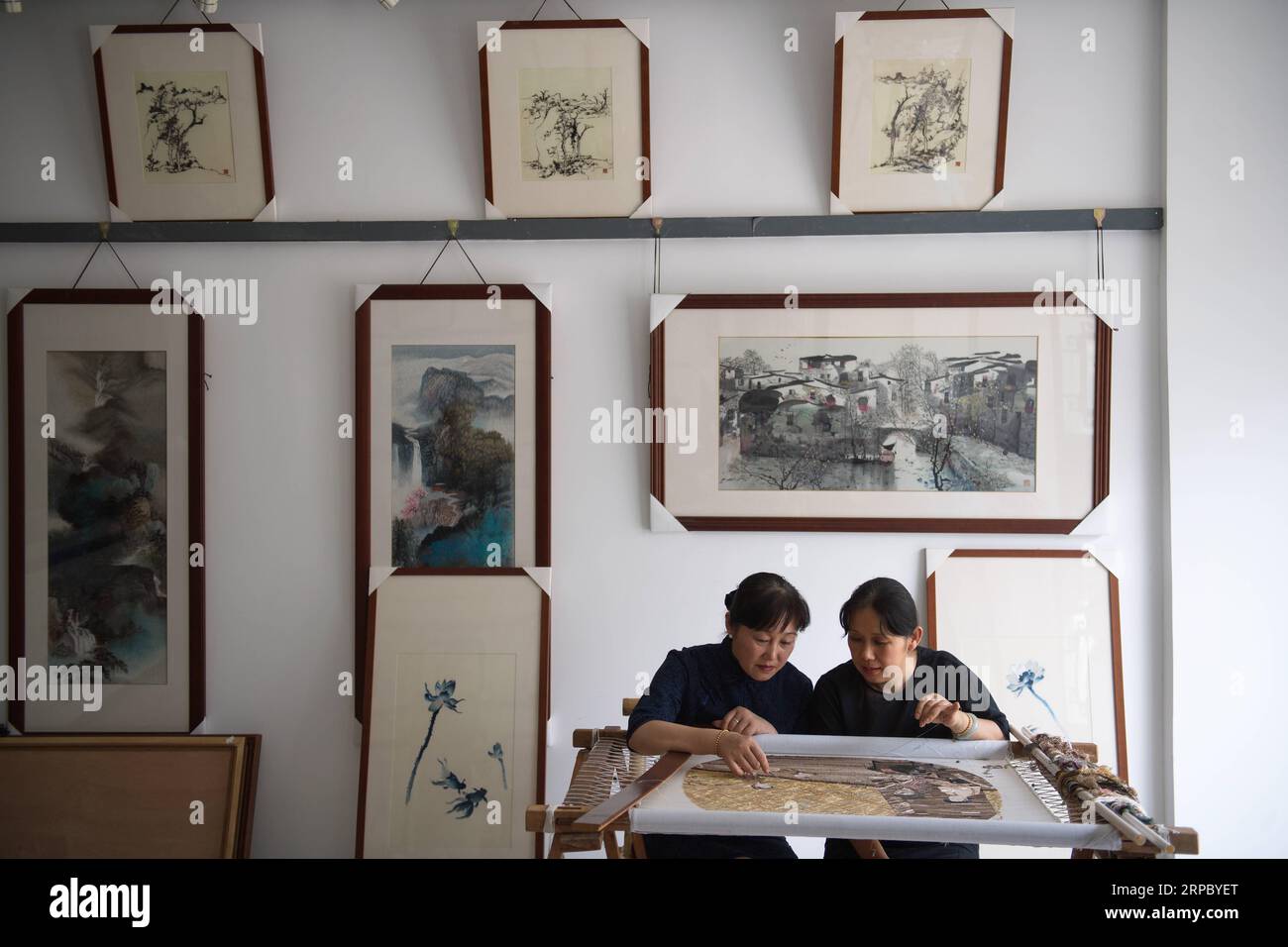 (190619) -- NANCHINO, 19 giugno 2019 (Xinhua) -- Yao Huifen (L) e sua sorella Yao Huiqin scambiano punti nel suo laboratorio nella città di Zhenhu di Suzhou, nella provincia di Jiangsu della Cina orientale, 11 giugno 2019. Il ricamo di Suzhou, uno dei quattro ricami più famosi della Cina, ha origine a Suzhou e ha una storia di oltre 2.000 anni. Noto per il suo elegante motivo, il design artistico, la raffinata lavorazione a mano e i vari punti, è stato inserito tra i patrimoni culturali immateriali nazionali della Cina nel 2006. Yao Huifen, erede rappresentativo del mestiere, nacque a Suzhou nel 1967 in una famiglia di ricami. In Foto Stock