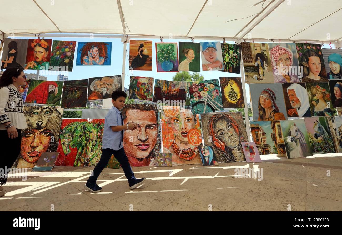 (190620) -- AMMAN, 20 giugno 2019 -- le persone camminano davanti ai lavori di pittura dei rifugiati al bazar estivo dell'UNHCR ad Amman, in Giordania, il 20 giugno 2019. In occasione della giornata mondiale dei rifugiati, giovedì l'UNHCR ha esortato la comunità internazionale a intensificare il sostegno alla Giordania per continuare i servizi ai rifugiati. ) GIORDANIA-AMMAN-UNHCR-RIFUGIATI-ESTATE BAZAAR MOHAMMADXABUXGHOSH PUBLICATIONXNOTXINXCHN Foto Stock