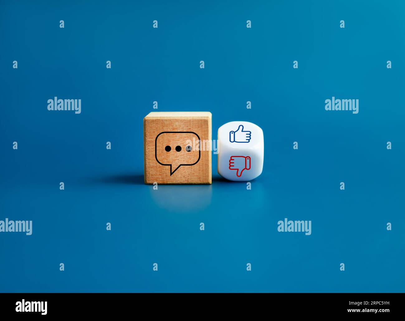 Commento online sui social media, post di accordo sui social network. Icona commento su un blocco di cubi in legno, come e a differenza del simbolo della mano sul dado bianco capovolto Foto Stock