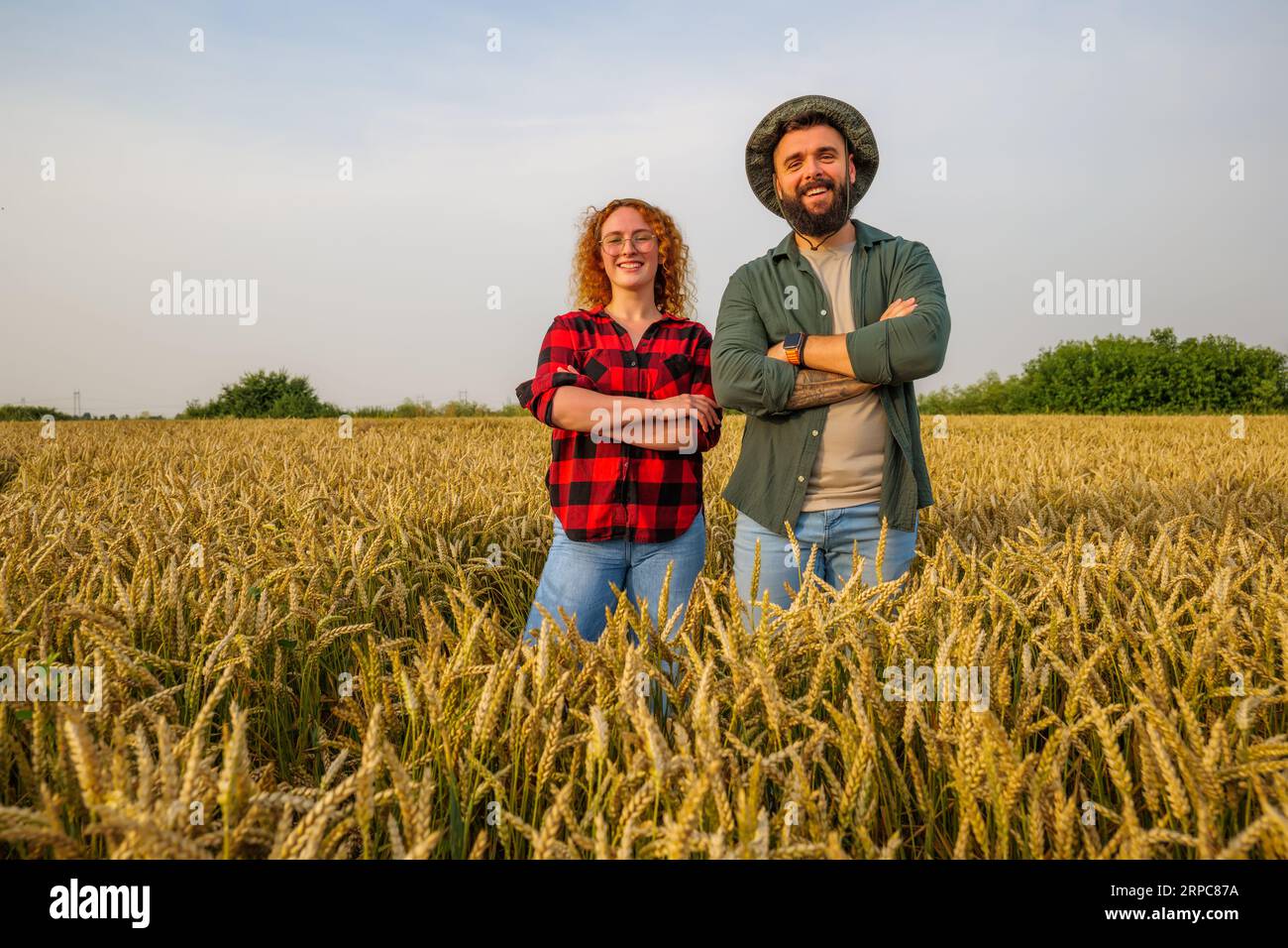 Occupazione agricola familiare. L'uomo e la donna coltivano il grano. Sono soddisfatti del buon progresso delle piante. Foto Stock
