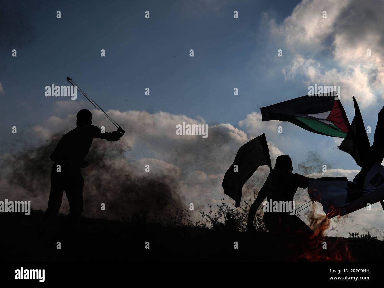 (190628) -- GAZA, 28 giugno 2019 (Xinhua) -- Un manifestante palestinese usa una fionda per lanciare pietre contro le truppe israeliane durante gli scontri sul confine tra Gaza e Israele, a est del campo profughi di al-Bureij nella Striscia centrale di Gaza, 28 giugno 2019. Almeno 50 palestinesi sono rimasti feriti venerdì negli scontri tra decine di manifestanti e soldati israeliani di stanza al confine tra la Striscia di Gaza orientale e Israele. (Xinhua/Yasser Qudih) MIDEAST-GAZA-CLASHES PUBLICATIONxNOTxINxCHN Foto Stock