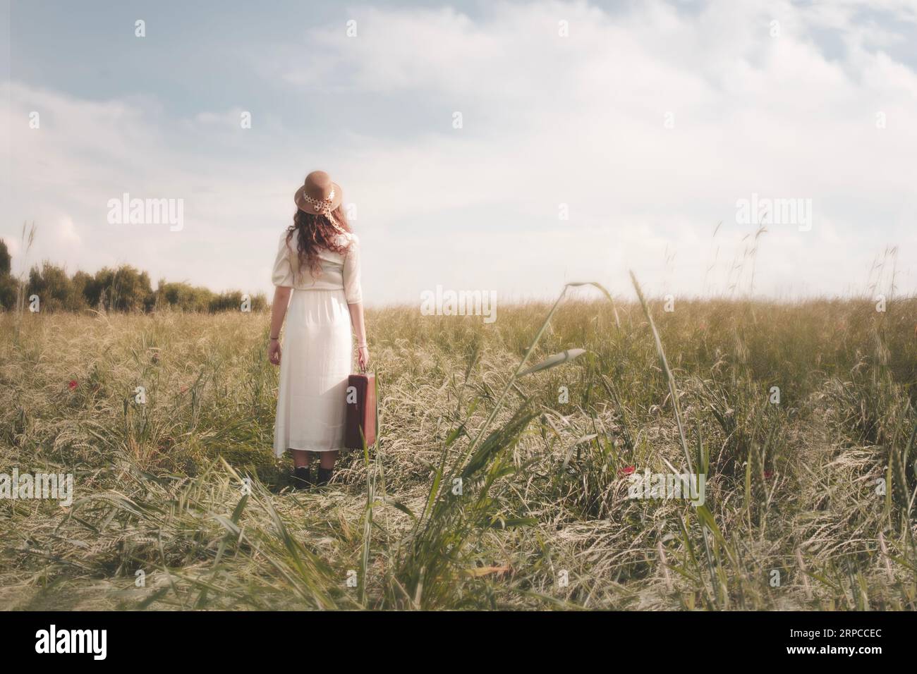 viaggiatore donna con valigia che cammina in un paesaggio di campagna surreale, concetto di mobilità nello spazio e nel tempo Foto Stock