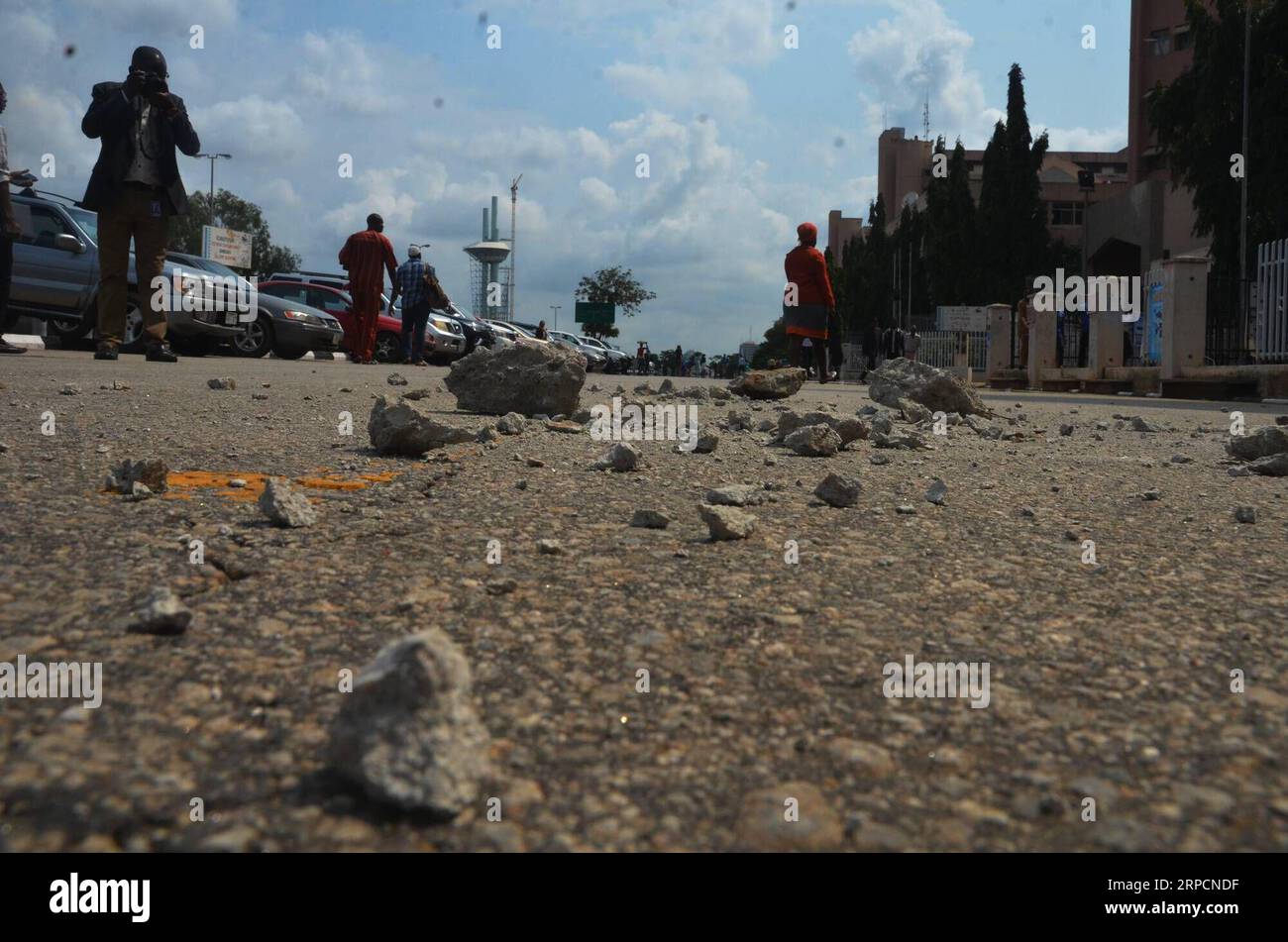 (190709) -- ABUJA, 9 luglio 2019 (Xinhua) -- le pietre sono viste disperse su una strada dopo una protesta ad Abuja, Nigeria, il 9 luglio 2019. Le autorità di polizia in Nigeria hanno detto che 40 manifestanti sono stati accoltellati martedì dopo un'invasione del parlamento nazionale da parte di membri del movimento islamico, noto anche come movimento sciita. Una marcia per il rilascio del leader del movimento islamico, lo sceicco Ibrahim El-Zakzaky e sua moglie sono diventati violenti quando centinaia di manifestanti hanno invaso il parlamento nella capitale. (Xinhua/Olatunji Obasa) NIGERIA-ABUJA-PROTESTA-VIOLENZA PUBLICATIONxNOTxINxCHN Foto Stock