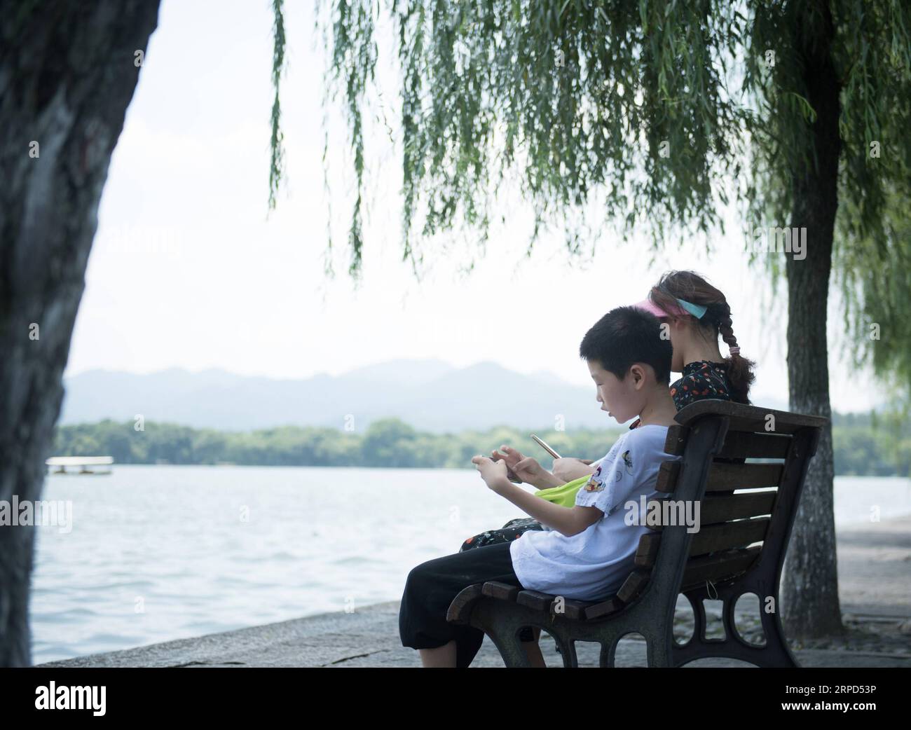 (190723) -- HANGZHOU, 23 luglio 2019 -- i turisti riposano vicino al Lago Occidentale a Hangzhou, nella provincia di Zhejiang nella Cina orientale, 23 luglio 2019. L'ondata di calore continua a colpire Hangzhou fino all'inizio di agosto.) CHINA-ZHEJIANG-HANGZHOU-HEAT WAVE (CN) WENGXXINYANG PUBLICATIONXNOTXINXCHN Foto Stock