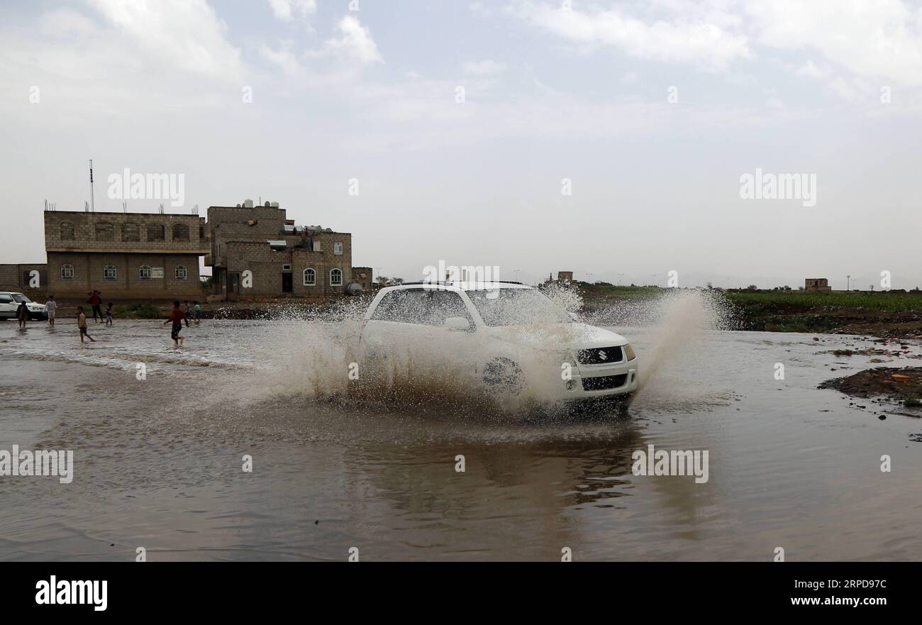 (190727) -- SANAA, 27 luglio 2019 -- Un'auto corre in acque alluvionali dopo una forte pioggia a Sanaa, Yemen, 26 luglio 2019. Piogge intense e inondazioni colpiscono spesso molti governatorati dello Yemen quest'estate. (Foto di Mohammed Mohammed/Xinhua) YEMEN-SANAA-FLOODS WangxWei PUBLICATIONxNOTxINxCHN Foto Stock