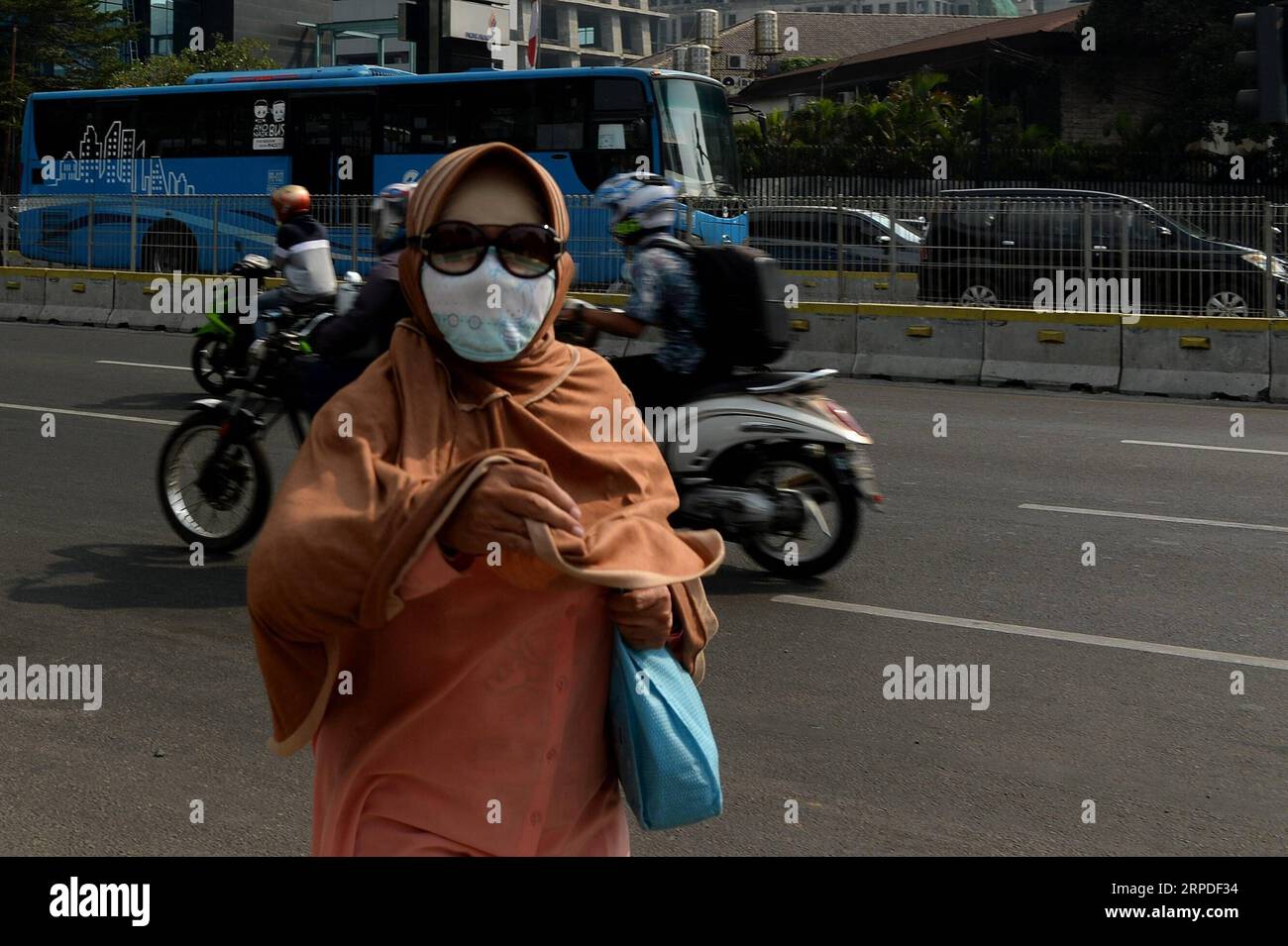 (190802) -- GIACARTA, 2 agosto 2019 -- Una donna indossa una maschera a causa dell'inquinamento atmosferico nelle strade di Giacarta, capitale dell'Indonesia, 2 agosto 2019. ) INDONESIA-GIACARTA-INQUINAMENTO ATMOSFERICO AGUNGXKUNCAHYAXB. PUBLICATIONxNOTxINxCHN Foto Stock