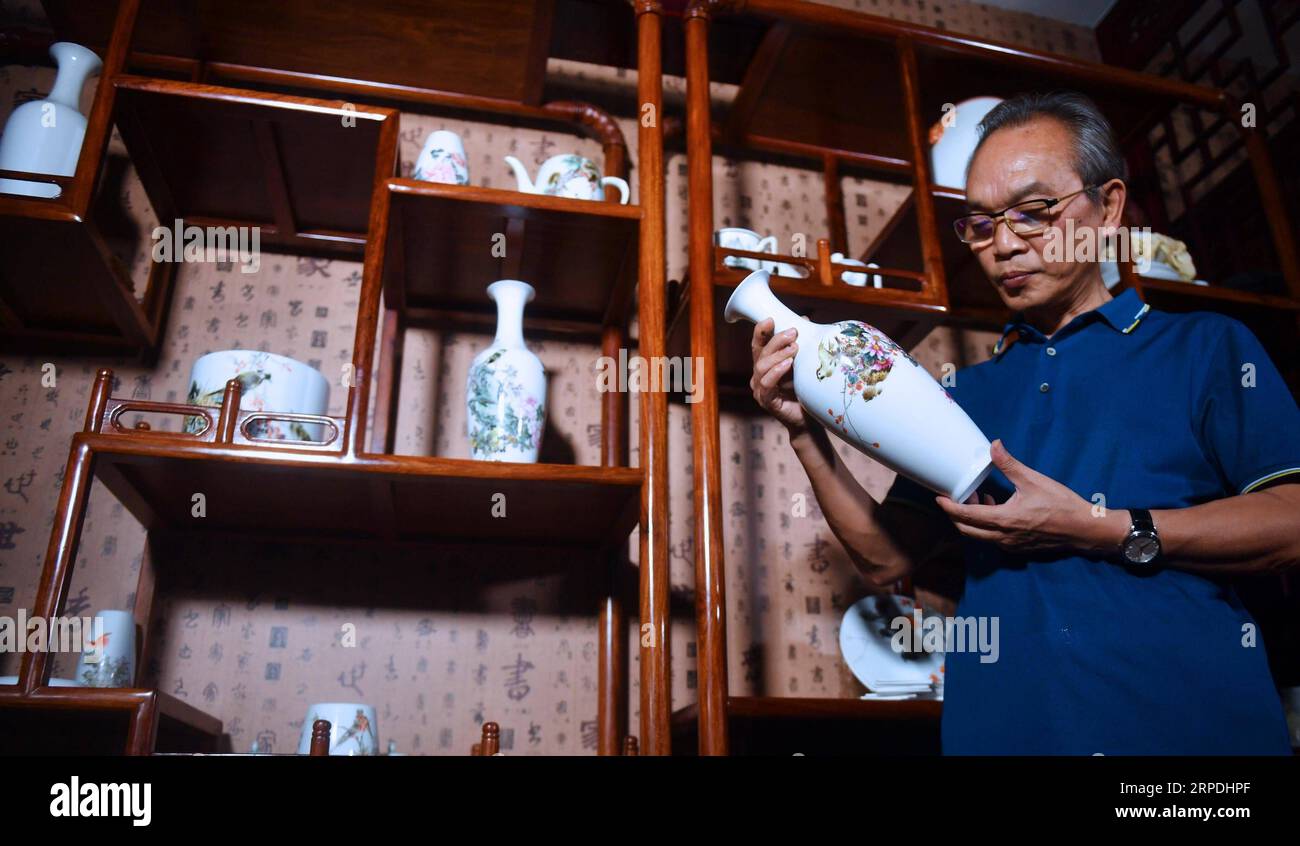 (190805) -- NANCHANG, 5 agosto 2019 -- Mao Guanghui controlla un pezzo di porcellana dipinta nel suo studio a Jingdezhen, provincia di Jiangxi, Cina orientale, 1 agosto 2019. Mao Guanghui, un maestro anziano di 56 anni di arti e mestieri nella provincia di Jiangxi, si dedica alla pittura di porcellana dall'età di 13 anni. Come discepolo di terza generazione di Deng Bishan (1874-1930), uno degli otto amici di Zhushan , un gruppo di artigiani di Jingdezhen ampiamente noti per le loro innovazioni nella pittura della porcellana, Mao ereditò non solo le abilità ma anche l'arte di creare pezzi di pittura della porcellana. L'argomento Foto Stock