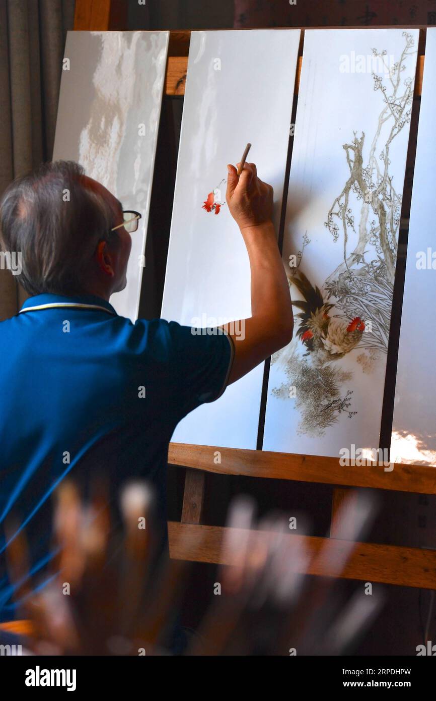 (190805) -- NANCHANG, 5 agosto 2019 -- Mao Guanghui lavora su un pezzo di pittura su lastre di porcellana nel suo studio a Jingdezhen, nella provincia di Jiangxi della Cina orientale, 1 agosto 2019. Mao Guanghui, un maestro anziano di 56 anni di arti e mestieri nella provincia di Jiangxi, si dedica alla pittura di porcellana dall'età di 13 anni. Come discepolo di terza generazione di Deng Bishan (1874-1930), uno degli otto amici di Zhushan , un gruppo di artigiani di Jingdezhen ampiamente noti per le loro innovazioni nella pittura della porcellana, Mao ereditò non solo le abilità ma anche l'arte di creare pezzi di pittura della porcellana. La Foto Stock