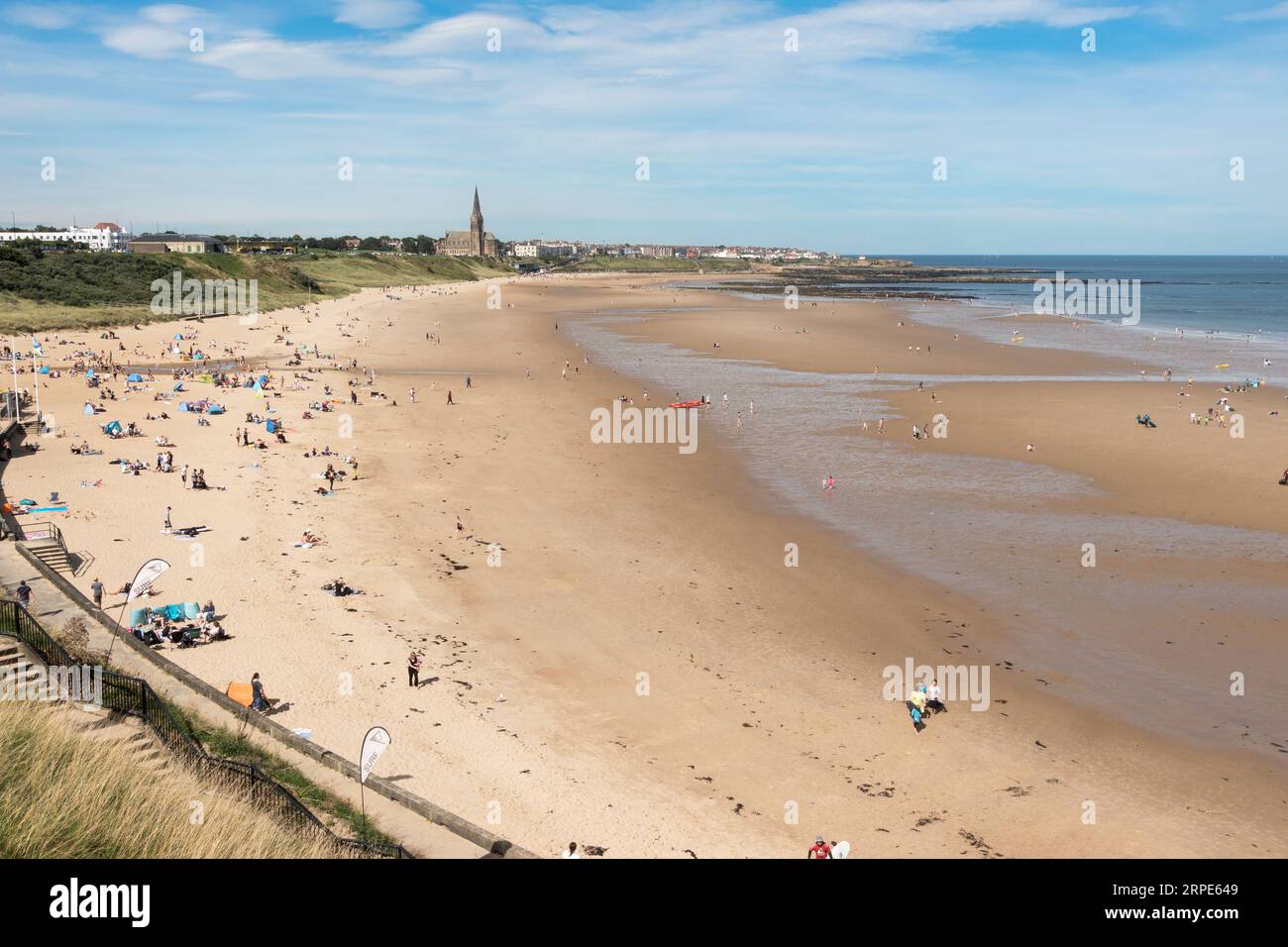 Gente che si gode il sole sulla spiaggia di Tynemouth Longsands, Inghilterra, Regno Unito Foto Stock