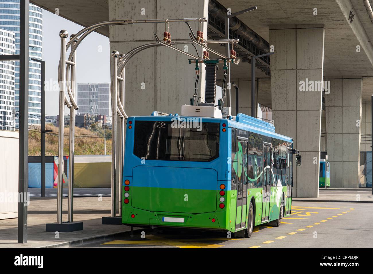 Il bus elettrico a una fermata viene caricato dal pantografo. Mobilità pulita. Foto Stock