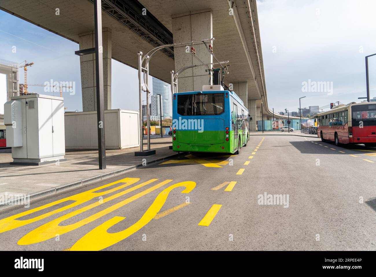 Il bus elettrico a una fermata viene caricato dal pantografo. Mobilità pulita. Foto Stock