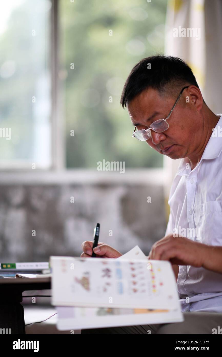 (190829) -- GUIYANG, 29 agosto 2019 -- Wu Guoxian prepara una lezione alla Gugang Primary School nel villaggio di Liuguang nella contea di Longli nella prefettura autonoma di Bouyei-Miao di Qiannan, nella provincia di Guizhou della Cina sud-occidentale, 26 agosto 2019. Situata nel profondo delle montagne, la scuola primaria Gugang nel villaggio di Liuguang ha accolto sei studenti dell'età prescolare e quattro studenti di prima elementare quando il nuovo semestre è iniziato lunedì. Saranno insegnati da Wu Guoxian, l'unico insegnante di scuola qui. Wu, 53 anni, ha lavorato nella scuola per 36 anni da quando si è diplomato in una scuola media nel 1983. La scuola aveva un insegnamento decrepito Foto Stock