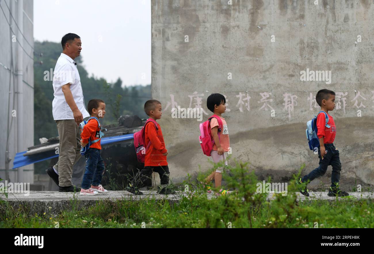 (190829) -- GUIYANG, 29 agosto 2019 -- gli studenti sono scortati da Wu Guoxian per tornare a casa al villaggio di Liuguang della contea di Longli nella prefettura autonoma di Bouyei-Miao di Qiannan, nella provincia di Guizhou della Cina sud-occidentale, 26 agosto 2019. Situata nel profondo delle montagne, la scuola primaria Gugang nel villaggio di Liuguang ha accolto sei studenti dell'età prescolare e quattro studenti di prima elementare quando il nuovo semestre è iniziato lunedì. Saranno insegnati da Wu Guoxian, l'unico insegnante di scuola qui. Wu, 53 anni, ha lavorato nella scuola per 36 anni da quando si è diplomato in una scuola media nel 1983. La scuola aveva un decrepito edificio di insegnamento Foto Stock