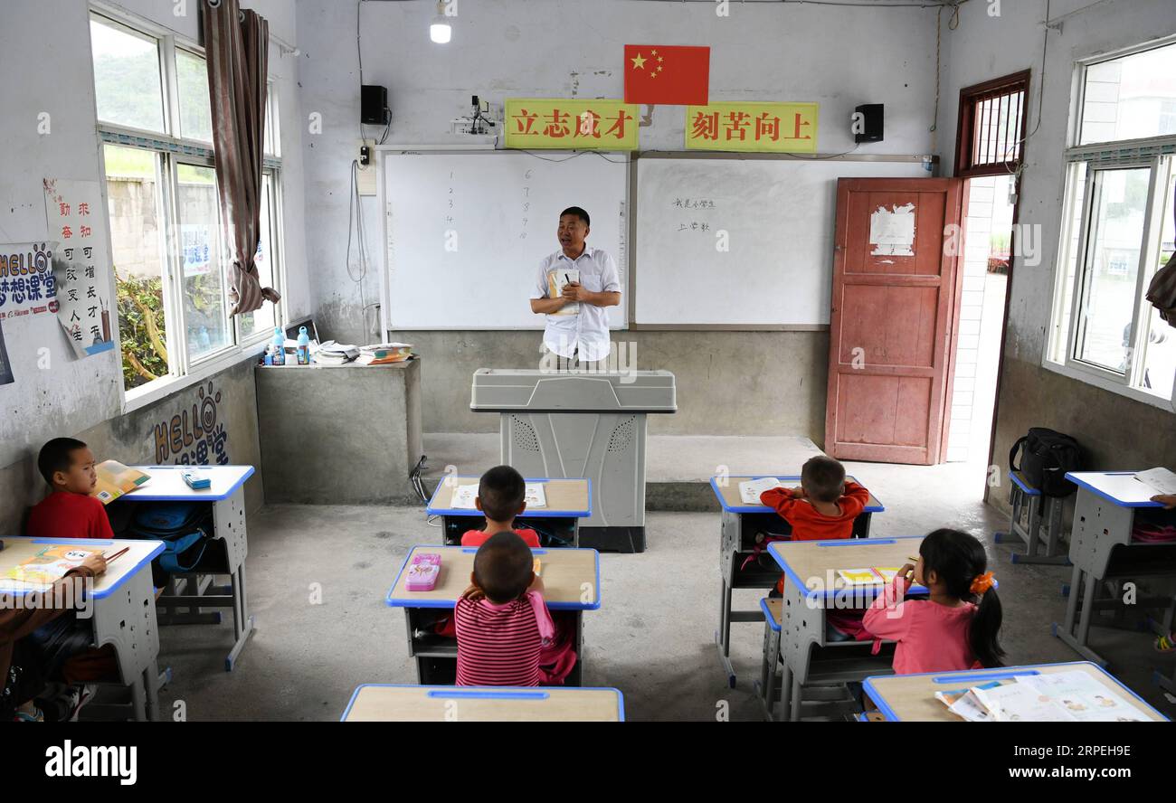 (190829) -- GUIYANG, 29 agosto 2019 -- Wu Guoxian dà una lezione agli studenti della Gugang Primary School nel villaggio di Liuguang nella contea di Longli nella prefettura autonoma di Bouyei-Miao di Qiannan, nella provincia di Guizhou della Cina sud-occidentale, 27 agosto 2019. Situata nel profondo delle montagne, la scuola primaria Gugang nel villaggio di Liuguang ha accolto sei studenti dell'età prescolare e quattro studenti di prima elementare quando il nuovo semestre è iniziato lunedì. Saranno insegnati da Wu Guoxian, l'unico insegnante di scuola qui. Wu, 53 anni, ha lavorato nella scuola per 36 anni da quando si è diplomato in una scuola media nel 1983. La scuola aveva un decrepi Foto Stock