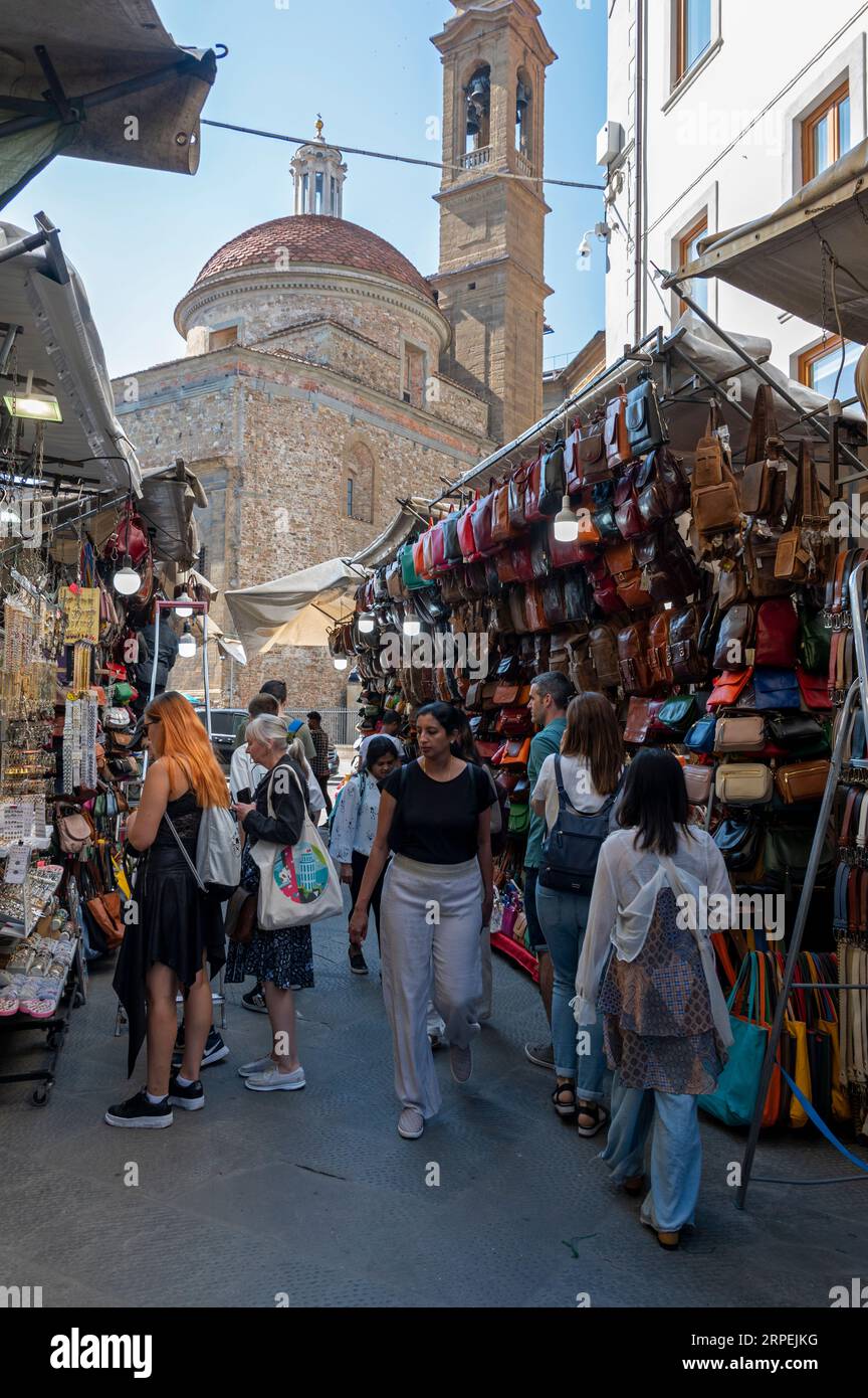 Commercianti che si preparano ad aprire il mercato locale della pelletteria vicino alla chiesa rinascimentale della Basilica di San Lorenzo ((Basilica di San Lawrence) Foto Stock