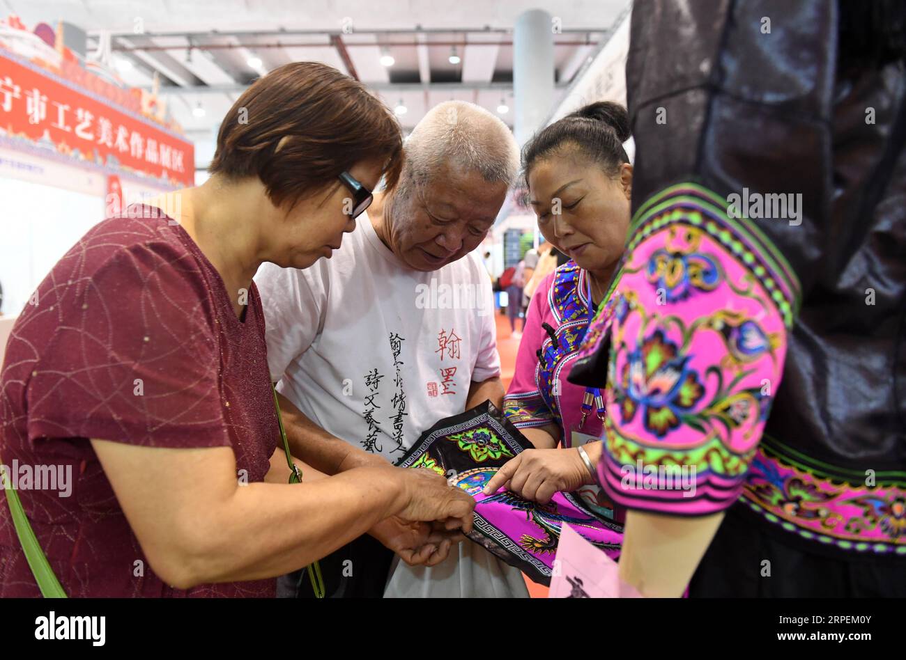 (190831) -- NANNING, 31 agosto 2019 -- i visitatori imparano a conoscere l'artigianato di un costume popolare al Nanning International Convention and Exhibition Center di Nanning, nella regione autonoma del Guangxi Zhuang nel sud della Cina, 31 agosto 2019. La mostra di quattro giorni sull'artigianato e le opere d'arte del Guangxi è iniziata qui il venerdì, con circa 20.000 opere d'arte provenienti da più di 500 imprese, università, istituzioni e individui esposti. CHINA-GUANGXI-NANNING-ART EXPO (CN) LUXBOAN PUBLICATIONXNOTXINXCHN Foto Stock