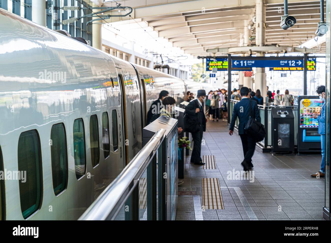 Osserva lungo la piattaforma della stazione le persone che sbarcano da un super espresso Tsubame Shinkansen serie 800 nella città giapponese di Kumamoto. Selettivo FOC Foto Stock