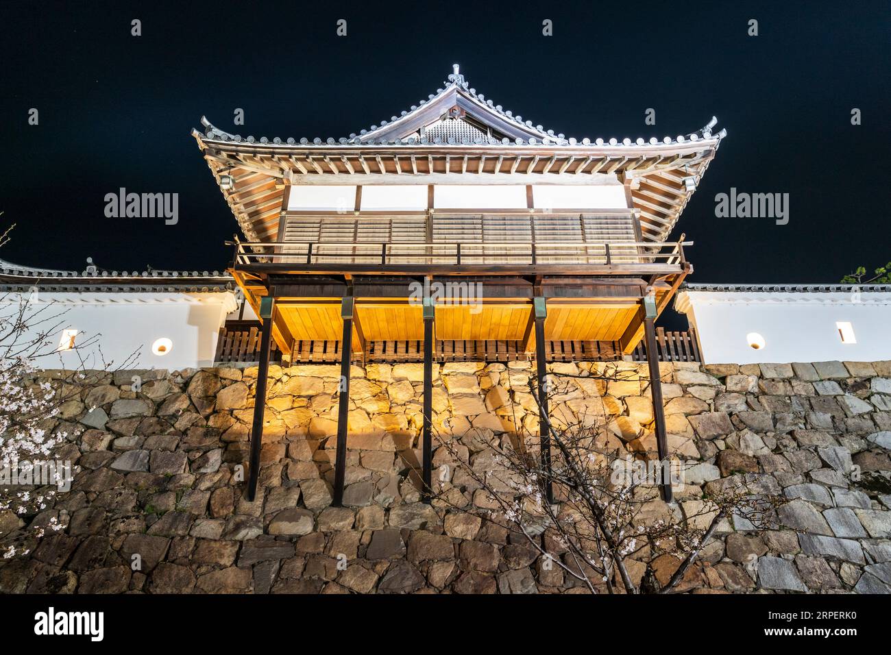 Bagno Yudono al castello di Fukuyama arroccato sul muro di pietra della cortina di Honmaru. Vista dall'angolo basso che guarda all'edificio in legno illuminato di notte. Foto Stock