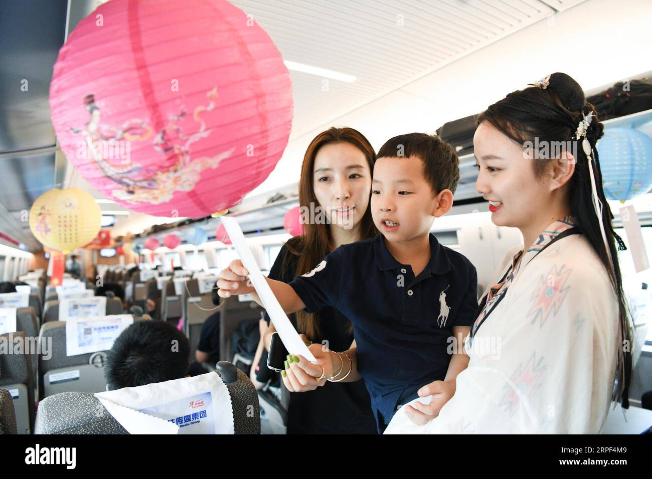 (190912) -- NANCHINO, 12 settembre 2019 -- Una hostess di treno (1st R) in costume tradizionale cinese e i passeggeri indovinate gli enigmi delle lanterne per salutare il prossimo Festival di metà autunno a bordo di un treno proiettile da Shanghai a Nanchino della provincia di Jiangsu della Cina orientale, 12 settembre 2019. Il Mid-Autumn Festival cade il 13 settembre di quest'anno. ) CHINA-MID-AUTUMN FESTIVAL-CELEBRATIONS (CN) LIXBO PUBLICATIONXNOTXINXCHN Foto Stock
