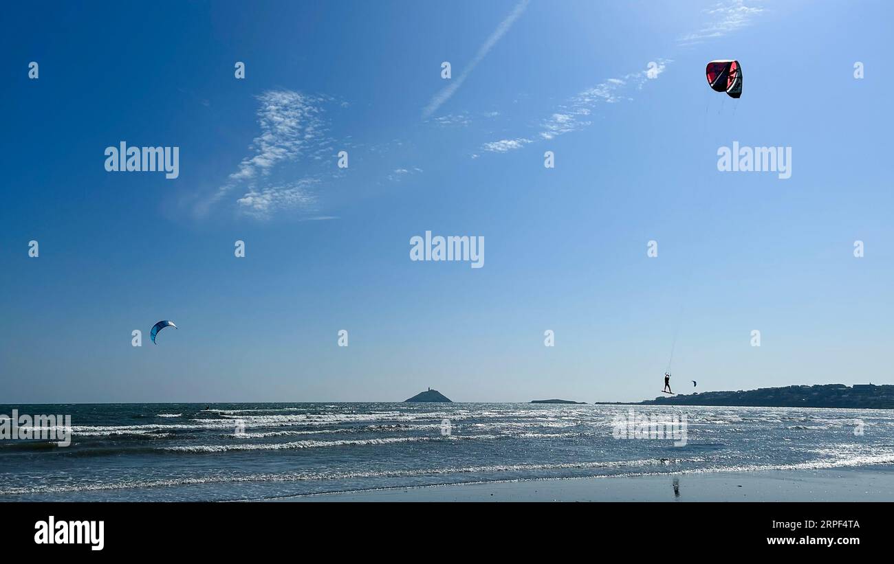 Qualcuno fa kitesurf nelle vivaci acque di Ballymona Beach vicino a Ballycotton, contea di Cork, Irlanda Foto Stock