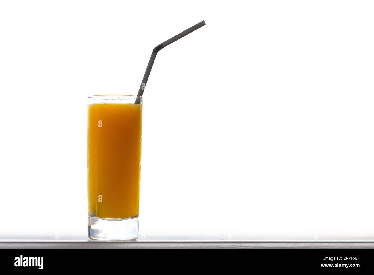 Un bicchiere di succo d'arancia fresco con paglia nera isolata su sfondo bianco Foto Stock
