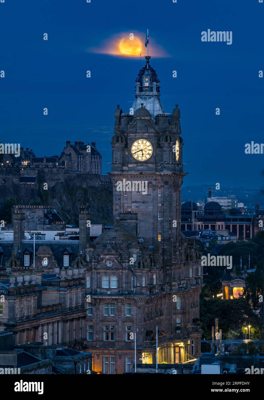 Skyline della città con una superluna blu piena sopra la torre dell'orologio Balmoral nel cielo nebbioso, Edimburgo, Scozia, Regno Unito Foto Stock