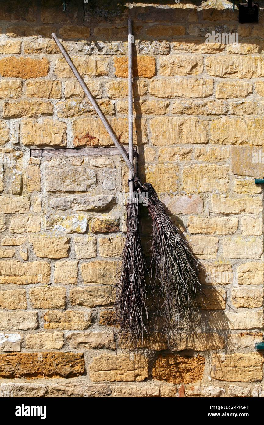 Spazzatrici streghe esposte su un muro del vecchio mulino. Foto Stock