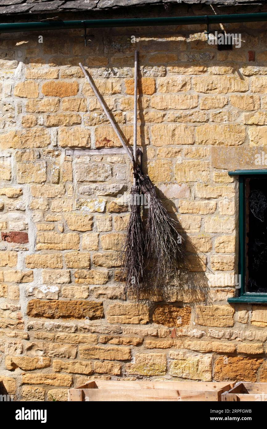Spazzatrici streghe esposte su un muro del vecchio mulino. Foto Stock