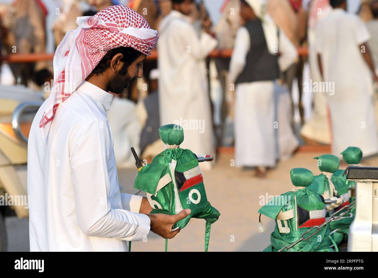 190929 -- AL AHMADI, 29 settembre 2019 -- Un uomo tiene un fantino robot da fissare sul dorso di un cammello da corsa nel Governatorato di al Ahmadi, Kuwait, 28 settembre 2019. I kuwaitiani amano la corsa dei cammelli, che è un evento sportivo molto popolare in Kuwait. Foto di Ghazy Qaffaf/Xinhua SPKUWAIT-AL AHMADI GOVERNATORATO-CORSA DI CAMMELLI NiexYunpeng PUBLICATIONxNOTxINxCHN Foto Stock