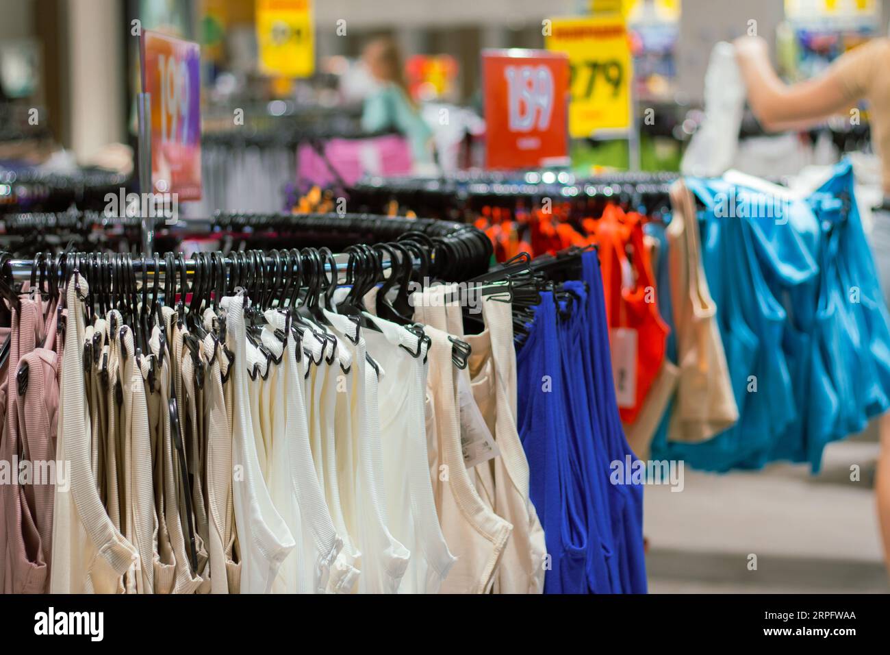 Abiti femminili su grucce. Vestiti nel negozio al dettaglio. Stagione di vendita nel settore della moda. Nuovi abiti da collezione. Interni dello showroom. Foto Stock