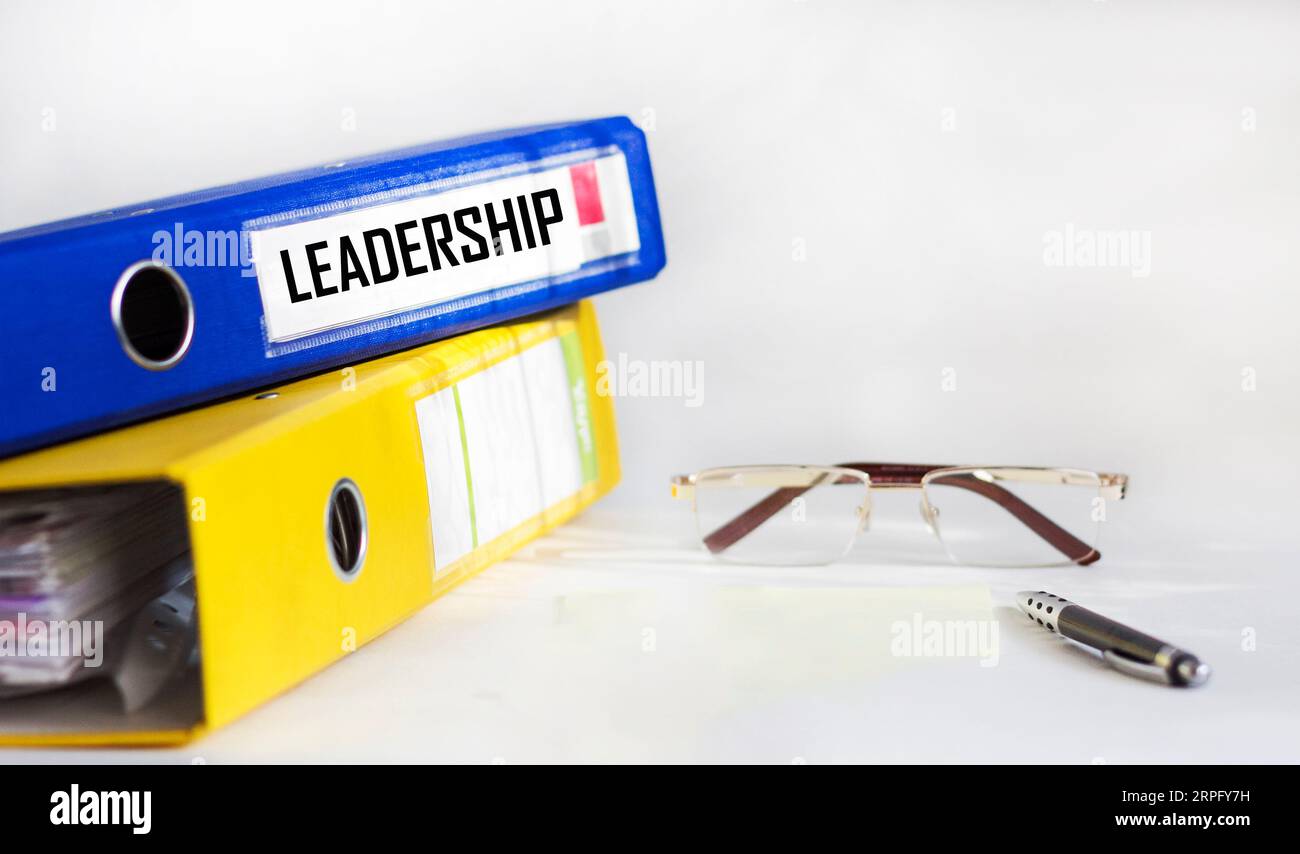 Definizione della parola leadership su una cartella blu su sfondo bianco Foto Stock