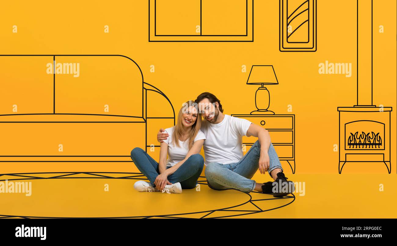 Positivo millenario coppia caucasica abbraccio sul pavimento, sogni di casa propria, isolato su sfondo arancione Foto Stock