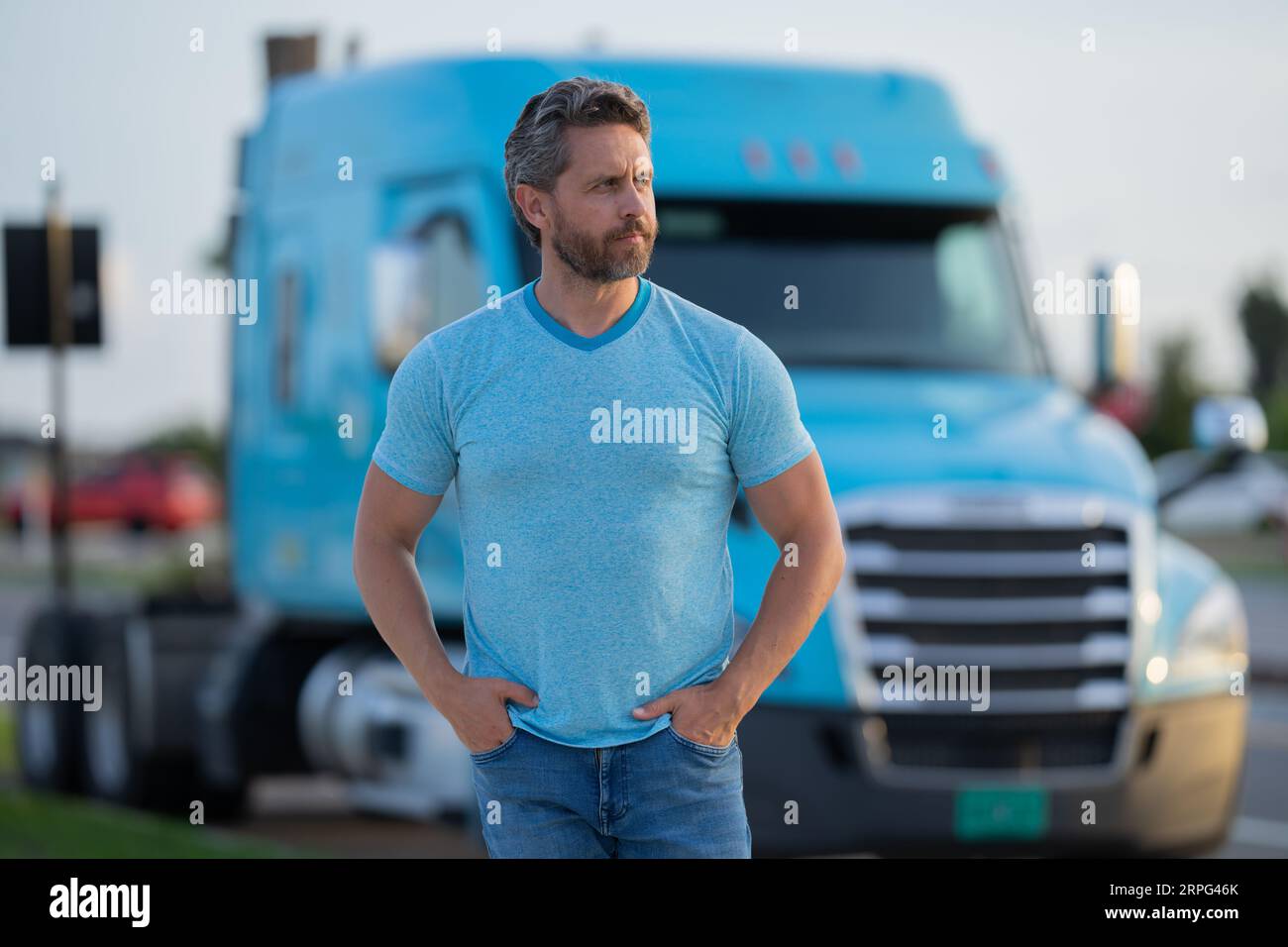 Conducente uomo vicino camion camion. Conducente del carrello. Proprietario del veicolo. Veicoli per il trasporto. Bell'uomo che si posa davanti al camion. Veicolo semi-autocarri Foto Stock