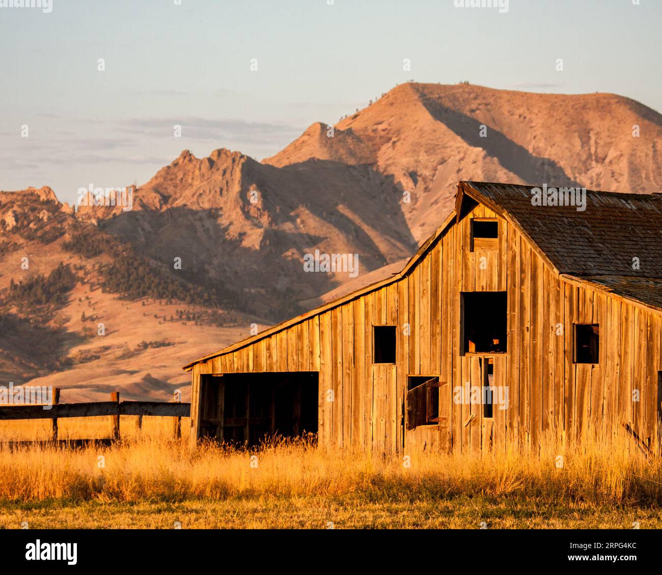 Old Barn di fronte a Bear Butte all'alba Foto Stock