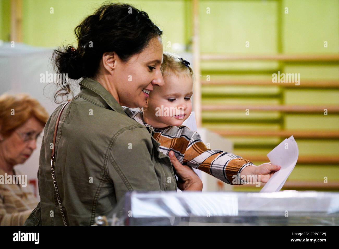 191014 -- PECHINO, 14 ottobre 2019 -- Una donna con un bambino pronuncia il suo voto in un collegio elettorale a Varsavia, in Polonia, il 13 ottobre 2019. Il sondaggio di uscita dopo la chiusura del voto in Polonia alle 21 di domenica ha indicato che il partito di legge e giustizia PiS ha vinto il 43,6% dei voti nelle elezioni parlamentari. Foto di /Xinhua XINHUA FOTO DEL GIORNO JaapxArriens PUBLICATIONxNOTxINxCHN Foto Stock