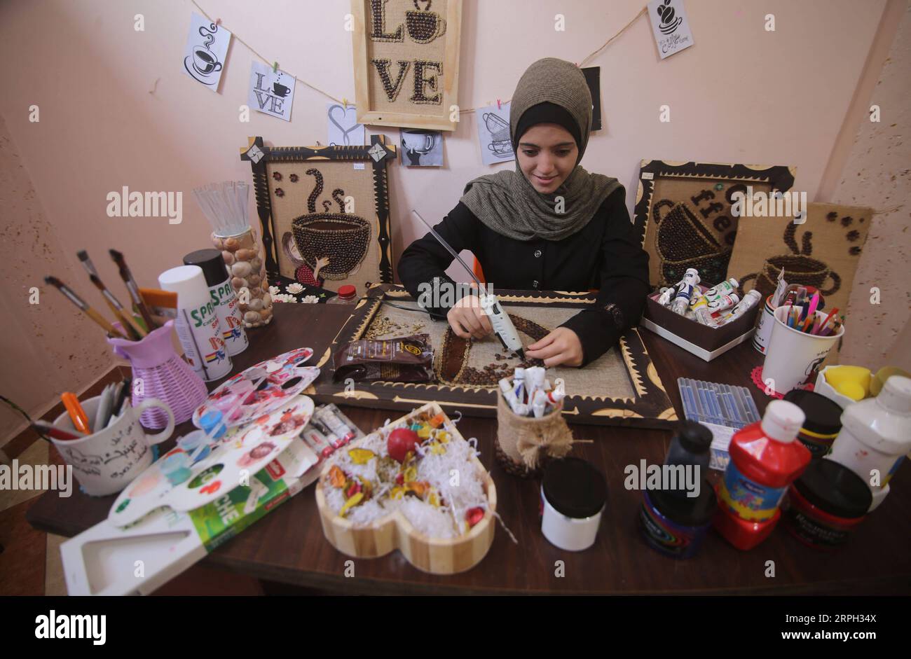 191028 -- GAZA, 28 ottobre 2019 -- l'artista palestinese Hala Abu Qaoud realizza opere d'arte utilizzando chicchi di caffè nella sua casa nella città meridionale di Rafah, nella Striscia di Gaza, 28 ottobre 2019. Abu Qaoud, 20 anni, studia belle arti in un'università locale a Gaza. Vende i suoi pezzi d'arte su piattaforme di social media. Foto di /Xinhua MIDEAST-GAZA-ART KhaledxOmar PUBLICATIONxNOTxINxCHN Foto Stock