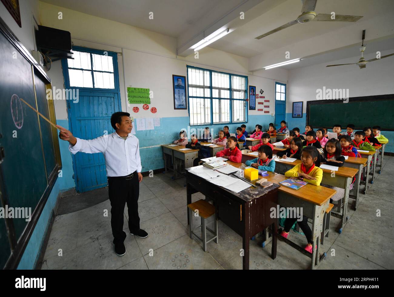 191029 -- LE AN, 29 ottobre 2019 -- Huang Xinglai dà una lezione agli studenti della scuola elementare Cunli di Huping Township in le An Country, provincia del Jiangxi della Cina orientale, 28 ottobre 2019. Huang Xinglai, 61 anni, era un insegnante rurale alla scuola elementare Anli di Wanchong Township e si ritirò nel luglio del 2018. Frequentò la scuola elementare Cunli di Huping Township e lavorò nuovamente come insegnante rurale nel gennaio del 2019 per rispondere all'appello del governo locale. Per concentrarsi sull'insegnamento, Huang vive a scuola con altri giovani insegnanti. Nel suo tempo libero, si prende cura degli studenti lasciati indietro, il cui pa Foto Stock