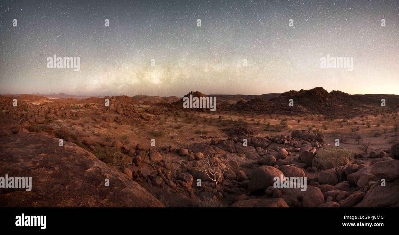 Il nucleo della via Lattea domina il paesaggio cosparso di massi di Damaland, Namibia. Foto Stock