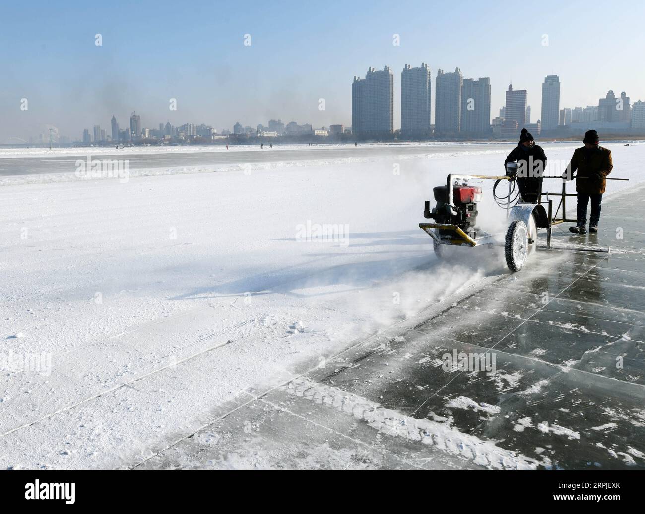 191207 -- HARBIN, 7 dicembre 2019 -- gli scavatori di ghiaccio usano una sega a motore elettrico per incidere il ghiaccio in una festa di scavo di ghiaccio a Harbin, capitale della provincia di Heilongjiang della Cina nord-orientale, 7 dicembre 2019. CHINA-HEILONGJIANG-HARBIN-ICE SCAVANDO CN QIANGXYONG PUBLICATIONXNOTXINXCHN Foto Stock