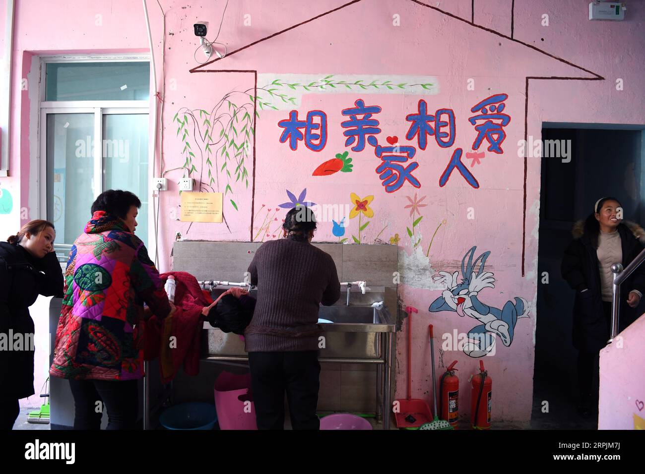 191214 -- HEFEI, 14 dicembre 2019 -- i genitori di bambini malati chiacchierano in un ostello vicino all'ospedale dei bambini di Hefei, provincia di Anhui della Cina orientale, 9 dicembre 2019. Vicino all'ospedale dei bambini di Hefei, c'è un edificio rosa a due piani, che viene affittato da un'organizzazione non governativa del benessere come ostello che fornisce camere gratuite a breve termine e auto-aiuto Love Kitchen per le famiglie colpite dalla povertà con bambini in cerca di cure mediche. Nella cucina dell'amore , acqua, elettricità, riso, farina, cereali, olio e utensili da cucina sono tutti disponibili gratuitamente. Per rendere la Love Kitchen più scorrevole Foto Stock