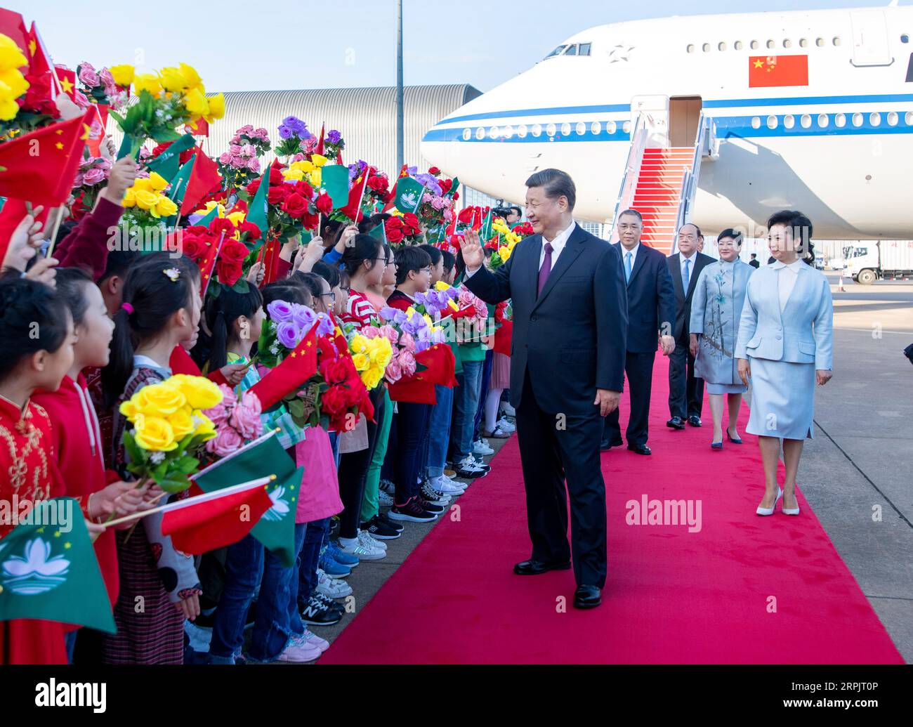 191218 -- MACAO, 18 dicembre 2019 -- il presidente cinese Xi Jinping, anche segretario generale del Comitato centrale del Partito Comunista Cinese e presidente della Commissione militare centrale, e sua moglie Peng Liyuan salutano la folla di benvenuto dopo l'atterraggio all'aeroporto internazionale di Macao a Macao, nel sud della Cina, il 18 dicembre 2019. Il presidente dovrebbe partecipare ad un raduno che celebra il ventesimo anniversario del ritorno di Macao e alla cerimonia di inaugurazione del quinto governo della regione amministrativa speciale di Macao venerdì. Ispezionerà anche la RAS di Macao. CHINA-MACAO-XI JINPING-ARRI Foto Stock