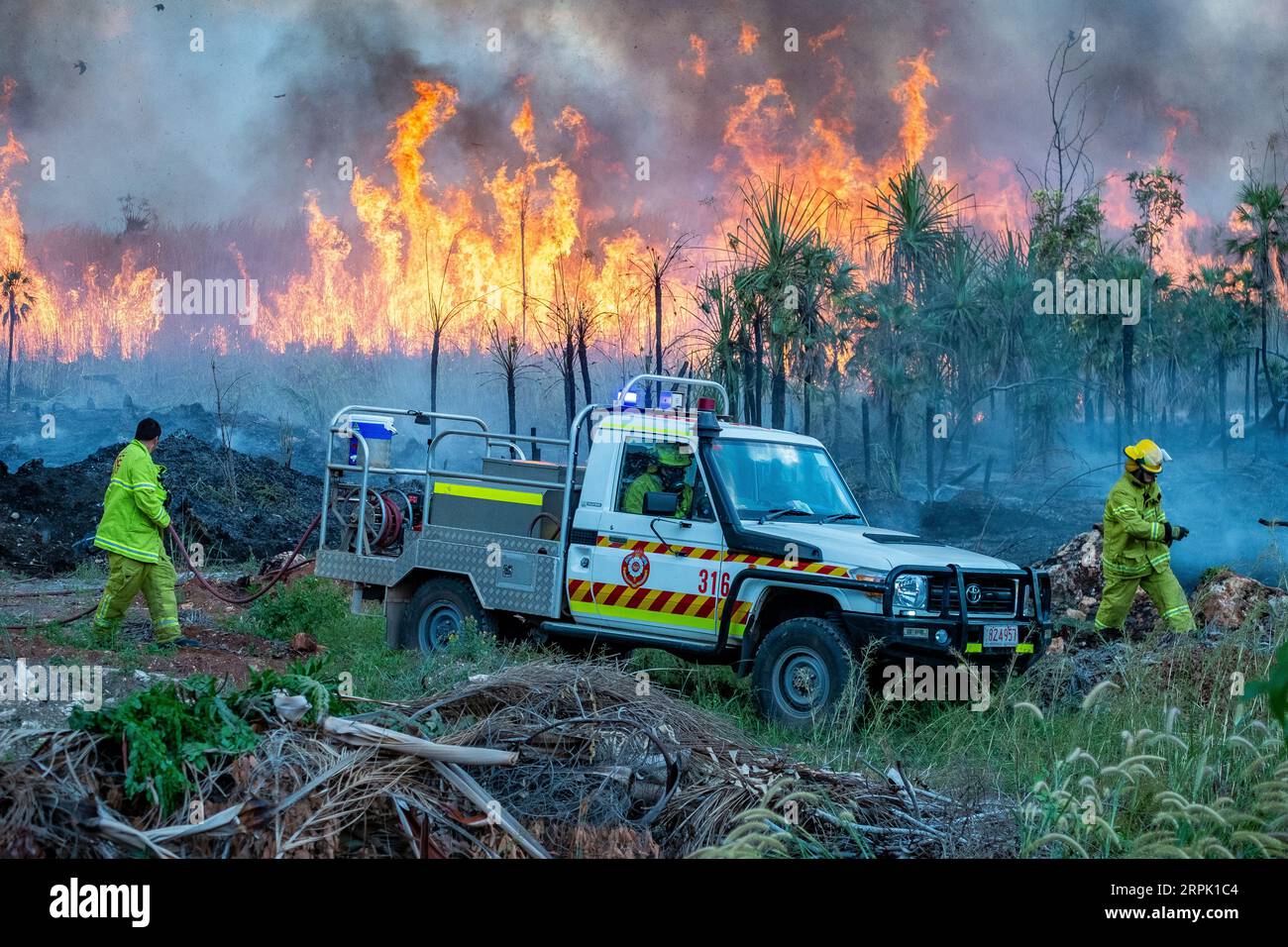 Servizi di emergenza vigili del fuoco che lavorano per controllare una fuga riduzione del rischio controllato bruciare nella macchia alla periferia di Darwin. Foto Stock