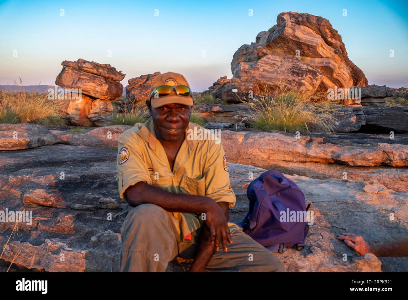 Guida turistica indigena al tramonto sulla cima della roccia di Ubirr nel Parco Nazionale di Kakadu nel territorio del Nord. Guida indigena, James Dempsey lavora per i Njanjma Rangers. Foto Stock