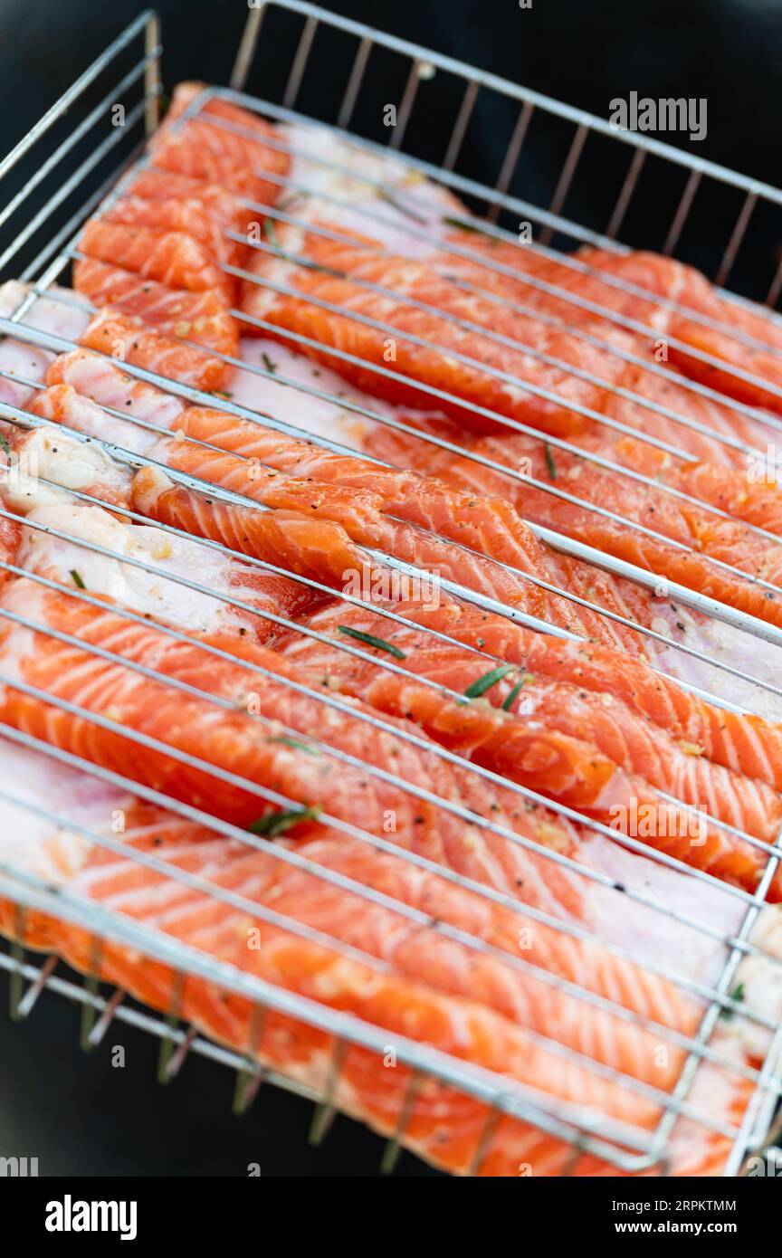 Cottura della bistecca di filetto di salmone crudo alla griglia con erbe aromatiche. Vista dall'alto Foto Stock