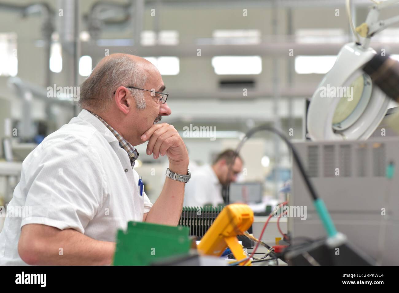 Ritratto di un lavoratore nel dipartimento di ingegneria di una fabbrica per la produzione e la costruzione di componenti elettronici Foto Stock