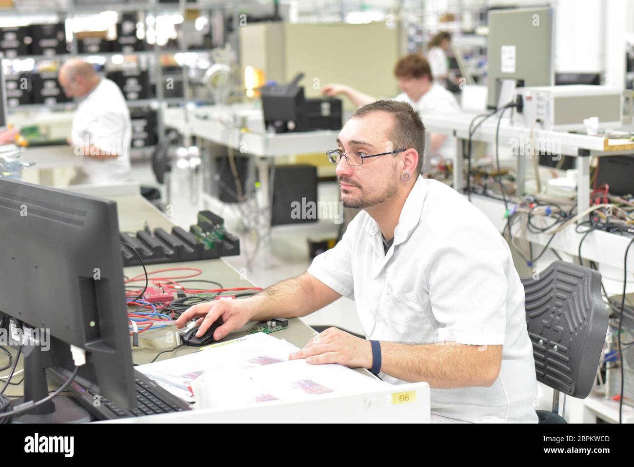 In ingegneria microelettronica: i lavoratori nella produzione e assemblaggio di electronic high tech componenti in un moderno stabilimento Foto Stock